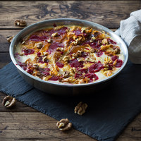 Traditional Russian dessert Guryev Porridge, Semolina porridge with dried fruits and walnuts, honey, cinnamon, cream, raspberry jam, pan on a wooden table, horizontal, coffee turka, star anise