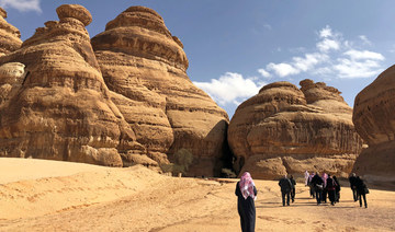 Visitors walk outside the tombs at the Madain Saleh antiquities site, AlUla, Saudi Arabia. (REUTERS)