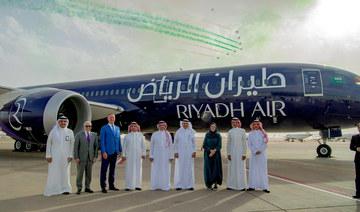 Officials pose for a photo in front of a Boeing 878-9 Dreamliner, KSA's newly launched airline Riyadh Air's plane. (REUTERS)